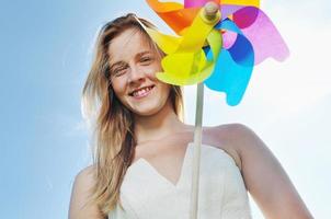linda noiva ao ar livre com brinquedo de moinho de vento colorido foto