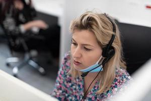 operador de call center com máscara médica foto