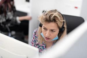 operador de call center com máscara médica foto