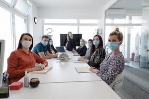 pessoas de negócios reais em reunião usando máscara protetora foto