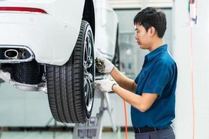 mecânico asiático verificando rodas de carro