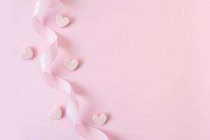 fita rosa e corações em um fundo rosa foto