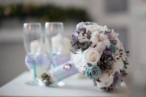 um buquê de casamento com flores brancas, roxas e azuis
