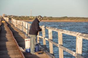 homem pescando no cais foto