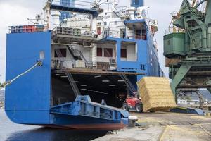 Varna, Bulgária - 19 de setembro de 2016. manipulador telescópico manitou fardos de carga em um navio. vista do dia. trabalhar no porto. foto