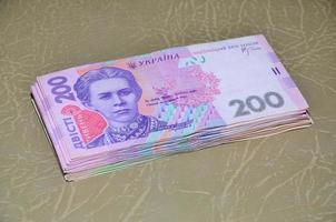 uma fotografia de close-up de um conjunto de dinheiro ucraniano com um valor nominal de 200 hryvnia, deitado sobre uma superfície de couro marrom. imagem de fundo em negócios na ucrânia foto