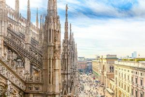 telhado da catedral de milão duomo di milano com torres góticas e estátuas de mármore branco. principal atração turística na piazza em milão, lombardia, itália. visão de grande angular da antiga arquitetura gótica e arte. foto