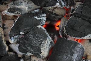 carvão ardente de laranja quente em uma churrasqueira. foto