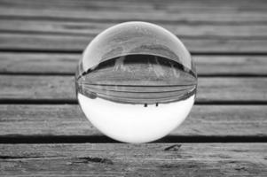 bola de vidro em um cais de madeira em um lago sueco ao entardecer em preto e branco. natureza foto