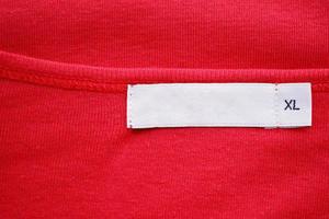 etiqueta de etiqueta de roupa branca em branco com tamanho xl na nova camisa vermelha foto