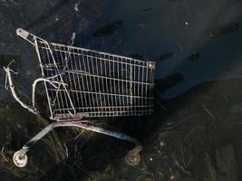 carrinho de compras descartado aparece no rio de maré baixa. foto
