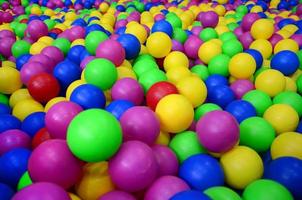 muitas bolas de plástico coloridas em uma piscina infantil em um playground. padrão de close-up foto