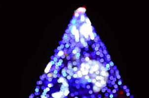 fragmento borrado da árvore do ano novo. muitas luzes redondas em azul foto