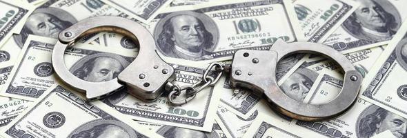 algemas da polícia estão em muitas notas de dólar. o conceito de posse ilegal de dinheiro, transações ilegais com dólares americanos. crime econômico foto