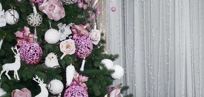 decorar a árvore de natal de perto. lâmpada de decoração, abeto, brinquedos de Natal rosa e luzes. use para fundo de celebração de natal e ano novo foto