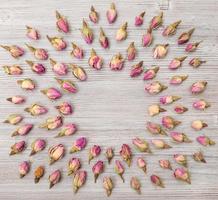 moldura redonda de flores rosas cor de rosa na prancha de madeira foto