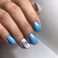 manicure azul nas unhas. manicure feminina na mão foto