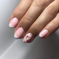 manicure bonita cor de carne nas unhas. manicure feminina foto