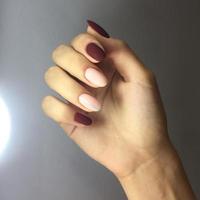 manicure de cores diferentes nas unhas. manicure feminina na mão em fundo cinza foto