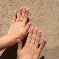 mãos femininas com manicure rosa elegante em fundo marrom foto