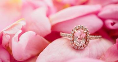 anel de diamante rosa de joias em um lindo fundo de pétalas de rosa close-up foto