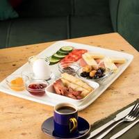 um tiro de close-up de um prato branco de café da manhã e uma xícara de café em uma mesa de madeira foto