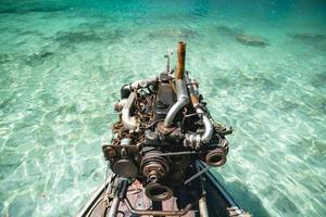 velha máquina de barco de pesca na água do mar azul claro na tailândia. foto