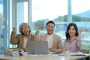 grupo de jovens empresários asiáticos colegas de trabalho criativos no escritório feliz em ser um trabalho em equipe de parceria bem-sucedida celebrando o conceito de conquista e sucesso. foto