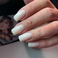 a mão de uma mulher com unhas de manicure brancas foto