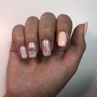 mulher com manicure cor de carne com design, close-up foto