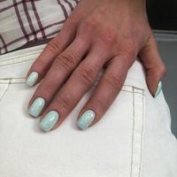 manicure azul feminino na moda elegante. mãos de uma mulher com manicure azul nas unhas foto