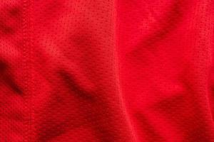 camisa de futebol de roupas esportivas de tecido vermelho com fundo de textura de malha de ar foto