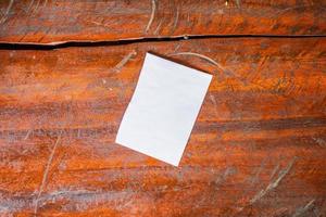 papel branco em branco sobre fundo de mesa de madeira rústica velha foto