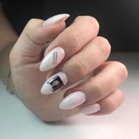 manicure rosa feminina na moda elegante. mãos de uma mulher com manicure rosa nas unhas foto