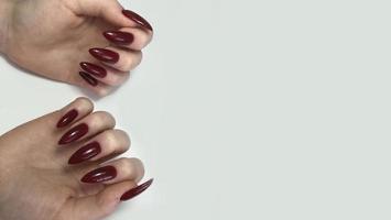 manicure feminino vermelho na moda elegante. mãos de uma mulher com manicure vermelho nas unhas foto