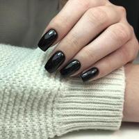 manicure feminina preta na moda elegante. mãos de uma mulher com manicure preta nas unhas foto