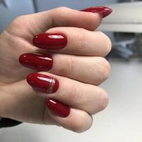 manicure feminino vermelho na moda elegante. mãos de uma mulher com manicure vermelho nas unhas foto