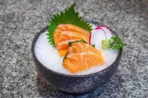 sashimi de salmão no gelo em tigela preta comida japonesa foto