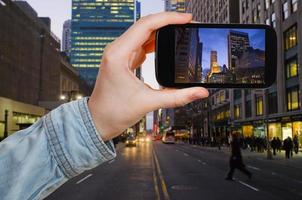 turista tirando foto de nova york à noite