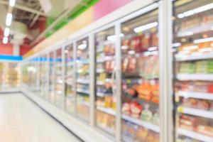 corredor de supermercado com freezer de geladeiras comerciais mostrando fundo desfocado abstrato de alimentos congelados foto