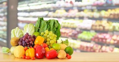 frutas e legumes frescos na mesa de madeira com supermercado desfocado fundo desfocado foto