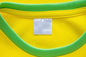 etiqueta de roupas têxteis em branco em branco na textura de jersey de tecido de roupas esportivas amarelas foto