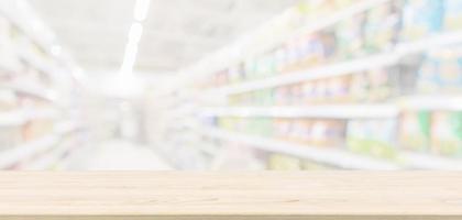 tampo de mesa de madeira vazio com corredor de supermercado abstrato de supermercado desfocado fundo desfocado com luz bokeh para exibição de produtos foto