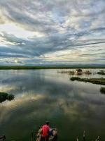 silhueta de um homem pescando à tarde foto