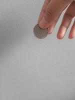 foto isolada de uma mão segurando uma moeda de mil rupias.