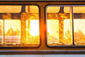 luz solar através das janelas sujas do ônibus velho foto