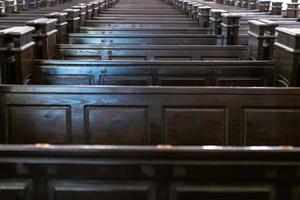 bancos da catedral. fileiras de bancos na igreja cristã. assentos de madeira sólidos pesados e desconfortáveis. foto