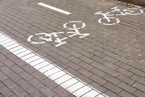 ciclovia em dois sentidos, marcando ciclovia na calçada, placa de bicicleta pintada de branco na estrada, símbolo de ciclo foto