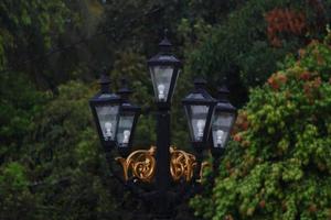 foto de lâmpada de iluminação de rua vintage tirada à noite ao lado de uma rua da cidade