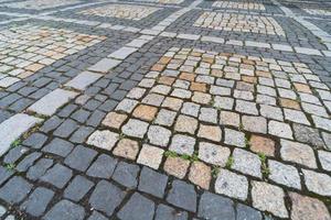 textura de azulejos. padrão de paralelepípedos alemão antigo no centro da cidade. pequenas pedras de granito para pavimentação. pavimentos cinzas antigos. foto